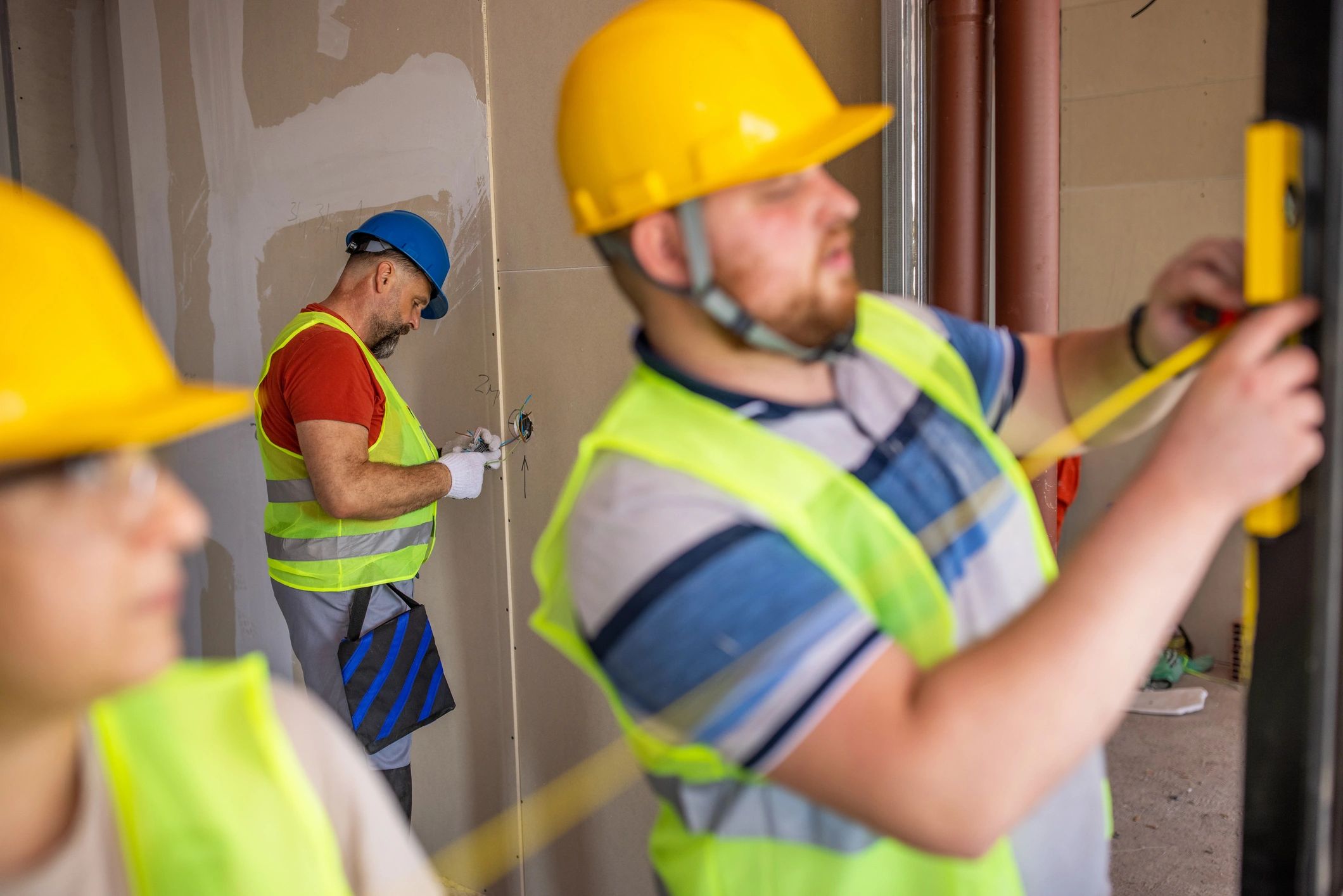 Contractors measuring and planning exterior installation work