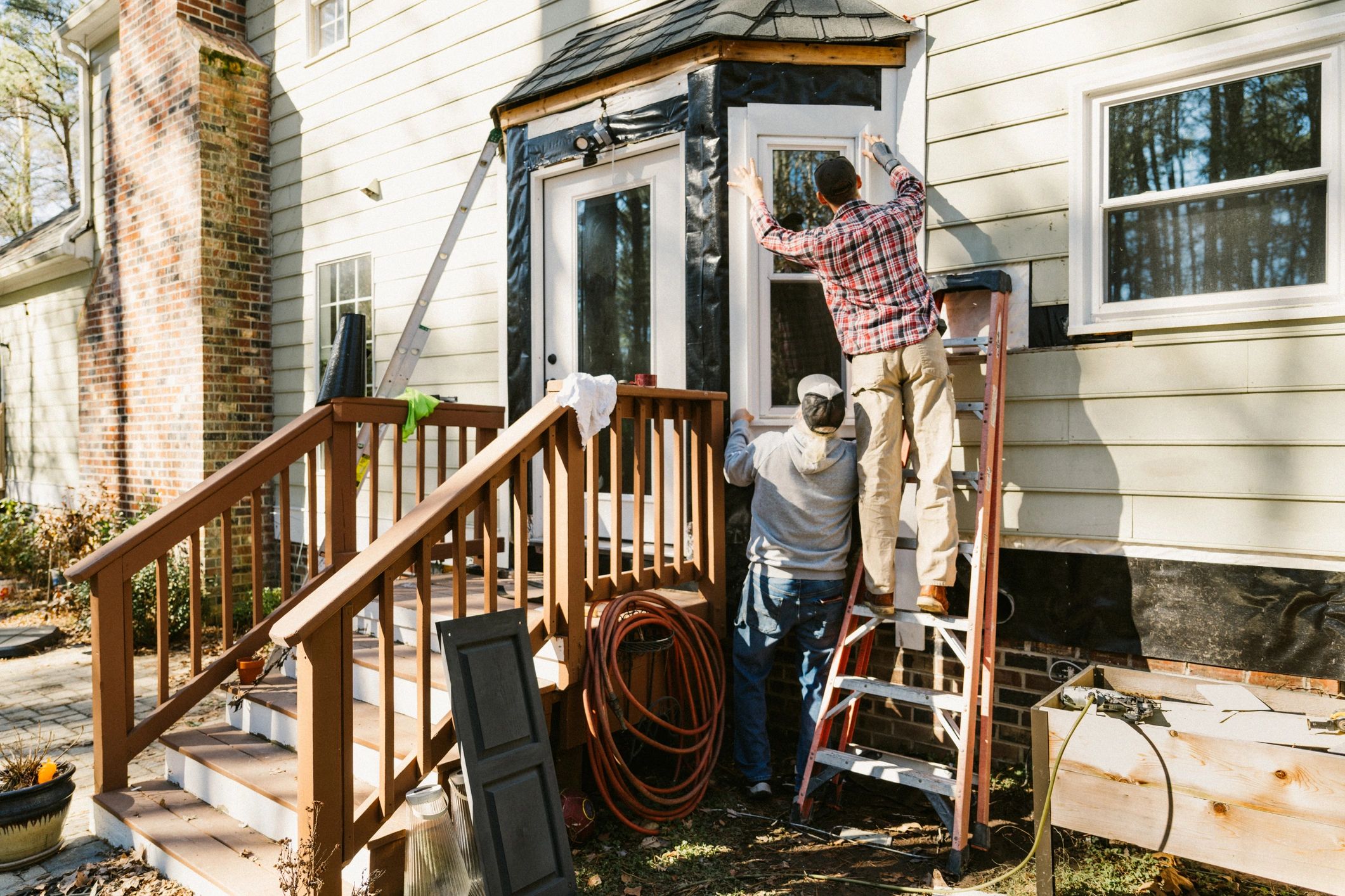 Crew working on house siding and exterior improvements